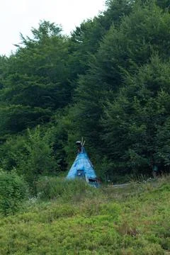Explore the uniqueness of a wigwam covered in blue polyethylene, nestled in t Stock Photos