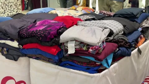 Explore a Vibrant Textile Assortment: Diverse Garments Neatly Folded for Sh.. Stock Footage 326034882