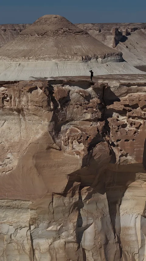 Explorer enjoying the panorama from a cliffs edge, Bozjyra, Mangystau Stock Footage 322826210