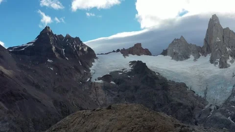 Explorer hiking on top of hill at the base of the Mount Fitz Roy Stock Footage 255687289