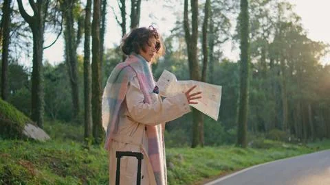 Explorer looking direction map standing roadside at autumn forest. Woman nature Stock Photos