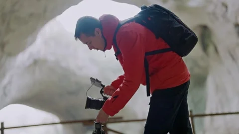 Explorer Man Sets Up Camera Tripod in Mysterious Cave 스톡 동영상 332073200