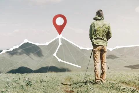 Explorer man standing in front of route with location GPS pin on peak of moun Stock Photos