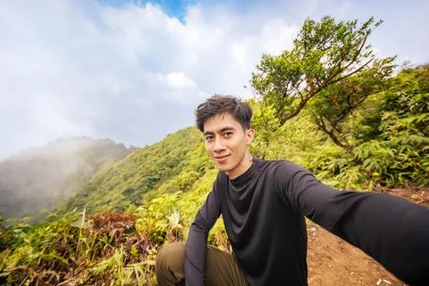 Explorer at the Peak, Capturing the Moment. Immersive View from Mountain Top. Stock Photos