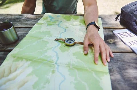 Explorer Planning Path using Map, Compass, Resting at Outdoors Table Stock Photos