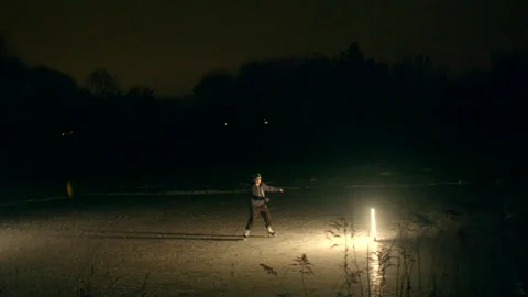 An explorer programs across icy terrain amid somber trees and atmospheric cold Video stock 347335706