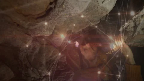 Explorer tapping cave rock with lamp for mapping while digital overlay 스톡 동영상 312004406