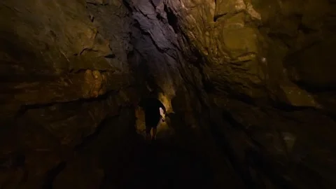 Explorer wading through a dark cave in the Jumandy Caverns Vídeos de archivo 334934275