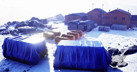 Explorers set up temporary shelter in a snowy landscape at dawn Vídeos de archivo 317053723