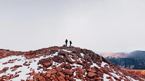 Explorers stand atop rocky summit in the Pyrenees, Spain Stock Footage 303624834