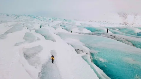 Explorers walk atop mountain range, aerial circle view 스톡 동영상 128522109