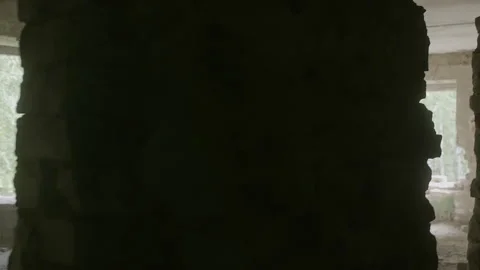 Exploring abandoned building through broken walls, revealing damaged interiors Stock Footage 301328467