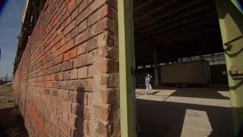 Exploring an abandoned warehouse at a deserted military base with a woman Stock Footage 319979685