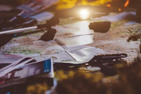 Exploring Adventure Hiking Concept. Looking navigation map in tent at night u Stock Photos
