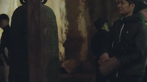 Exploring ancient bell in a cave with friends at night Stock Footage 312242678