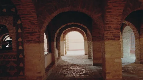 Exploring Ancient Moroccan Architecture: A Walk Through Tile and Brick Archways Stock Footage 311930432