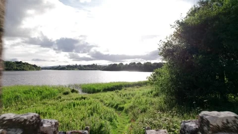 Exploring ancient ruins near a tranquil lake in the countryside Stock Footage 310241572