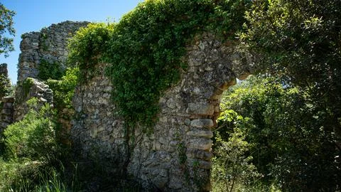 Exploring an ancient stone archway covered in ivy in the Moorish village of.. Stock Photos