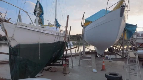 Exploring around a rustic boat yard nestled at the water's edge of a sleepy bay Video stock 107649971