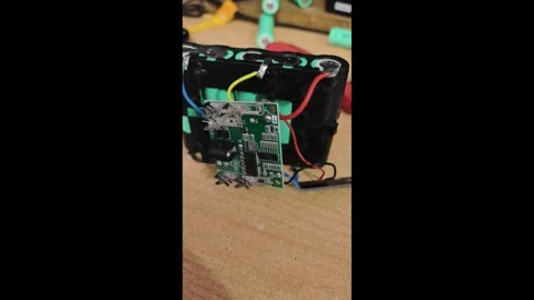 Exploring a battery pack circuit board with wires and connections at a workbench Stock Footage 336127453