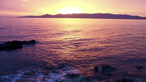 Exploring a beach in Greece during a gold and purple dusk. Clip with sound Stock Footage 143840825