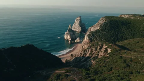 Exploring the beautiful beach coast and rocky cliffs at sunset Stock Footage 321480121