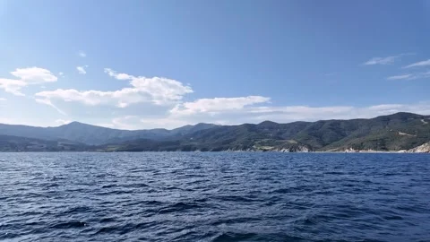 Exploring the blue waters and mountain views near the coast on the boat in the Видео 334689809