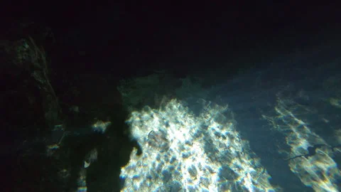 Exploring bottom of cenote Sun Rays Shine Trough Water Surface Mexico Yucatan Stock Footage 253192971