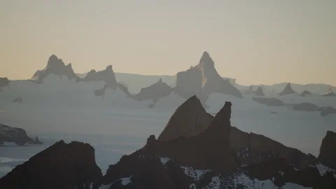 Exploring the breathtaking Antarctica mountains with a snow drone at dusk Stock Footage 288177401
