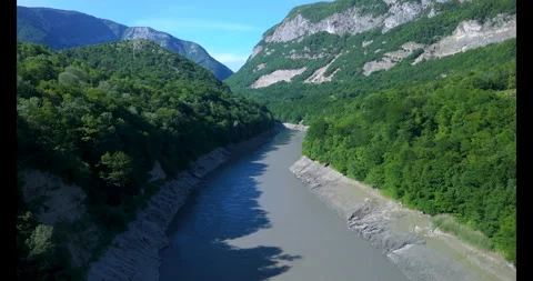 Exploring the breathtaking riverside landscape surrounded by majestic mountains Stockbeeldmateriaal 314083454