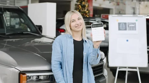 Exploring a car showroom with a customer checking details on a tablet Stock Footage 312665625