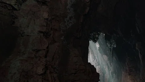 Exploring a cave with light streaming through rock formations in nature Stock Footage 342068242