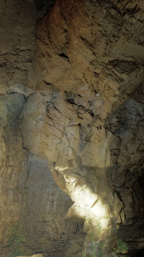 Exploring a cave with rock formations and a bright light in the background Stock Footage 331758683