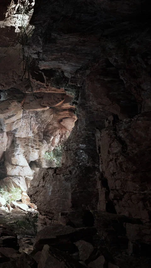 Exploring a cave with rock formations and light sources in the evening Stock Footage 340876916