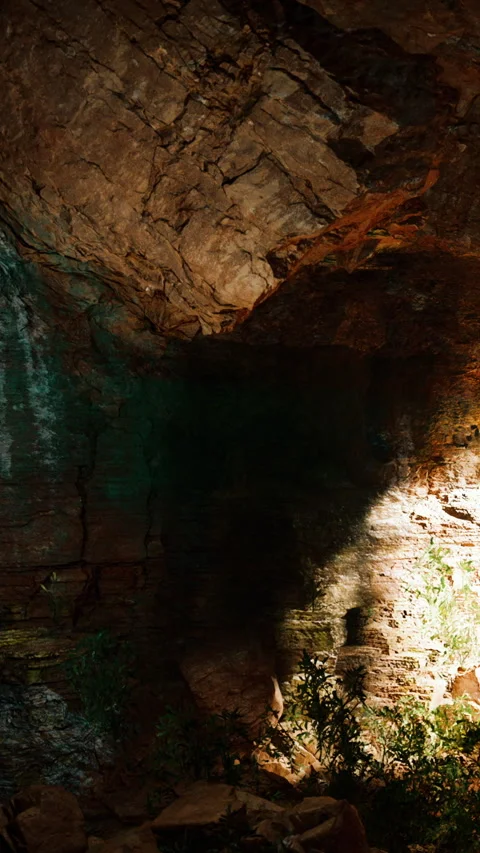 Exploring a cave with rugged rocks and shadows in natural light Stock Footage 341249282
