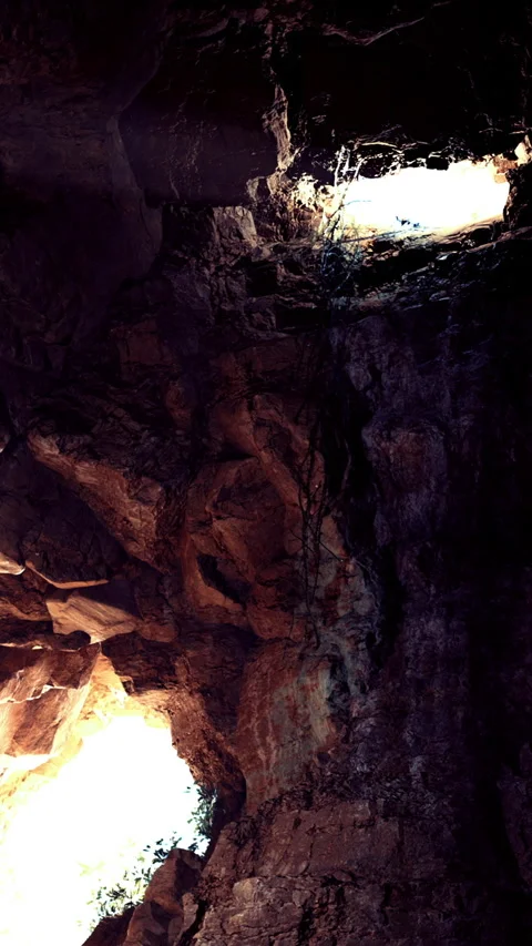 Exploring cave walls with light shining through openings in rocky surfaces Stock Footage 331752933