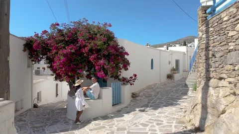 Exploring the charming streets of Paros Greece under blooming bougainvillea Stock Footage 337359299