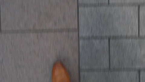 Exploring city streets while wearing stylish brown boots on a sunny day Stock Footage 310240878