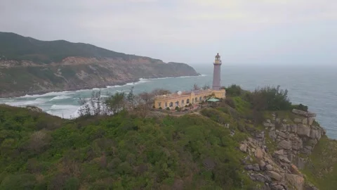 Exploring the coastal lighthouse on a rugged shoreline at sunset 스톡 동영상 310851541