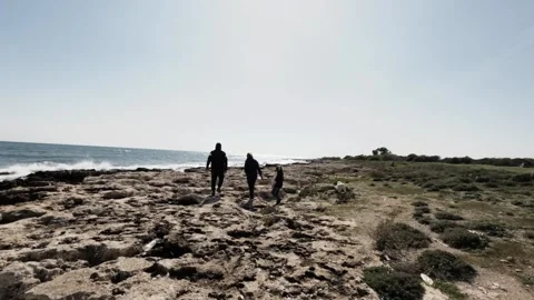 Exploring a coastal path with friends on a sunny day near the ocean Stock Footage 302352064