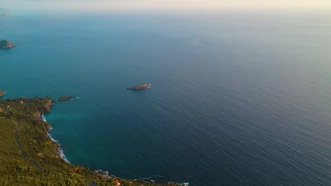 Exploring the Coastline and Distant Island Near the Ocean During Sunset at a Stock Footage 322933857