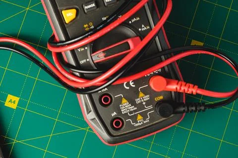 Exploring colorful electrical testing tools on a green surface Stock Photos