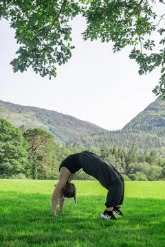 Exploring Creative Flexibility in Nature Through a Dynamic Yoga Pose in the Stock Photos
