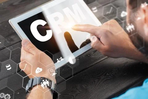 Exploring CRM tools on a tablet in a workspace setting during daytime hours Stock Photos