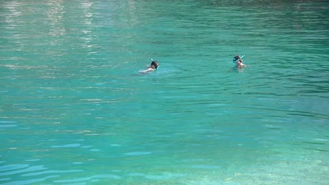 Exploring Crystal Waters: Two Snorkelers Enjoying the Vibrant Turquoise Sea on a Stock Footage 318093348