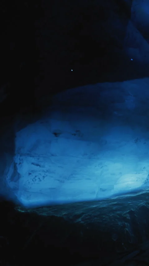 Exploring a dark cave with bright lights in the background at night Stock Footage 334167537