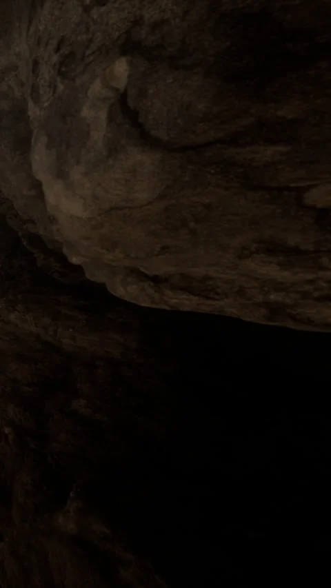Exploring dark cave with large rock formations near entrance Stock Footage 341988995