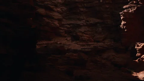 Exploring a dark cave with visible rock formations and shadows Stock Footage 340027895