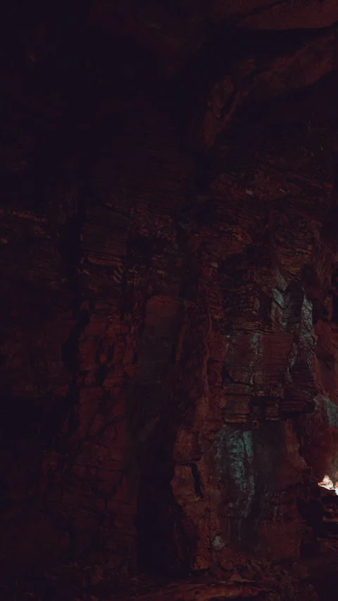 Exploring dark underground cave with rocky walls and faint light source Stock Footage 341264686