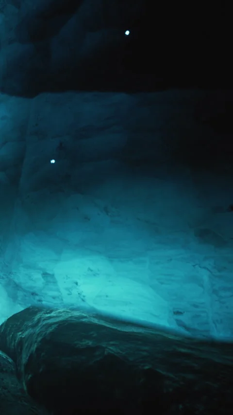 Exploring the deep cave with blue light shining on the rock surface Stock Footage 338000937